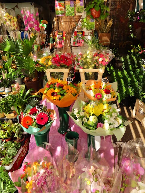 An indoor display of fresh flower arrangements at a local flower shop, featuring vibrant bouquets with various blooms including gerbera daisies, sunflowers, and mixed seasonal flowers in shades of yel